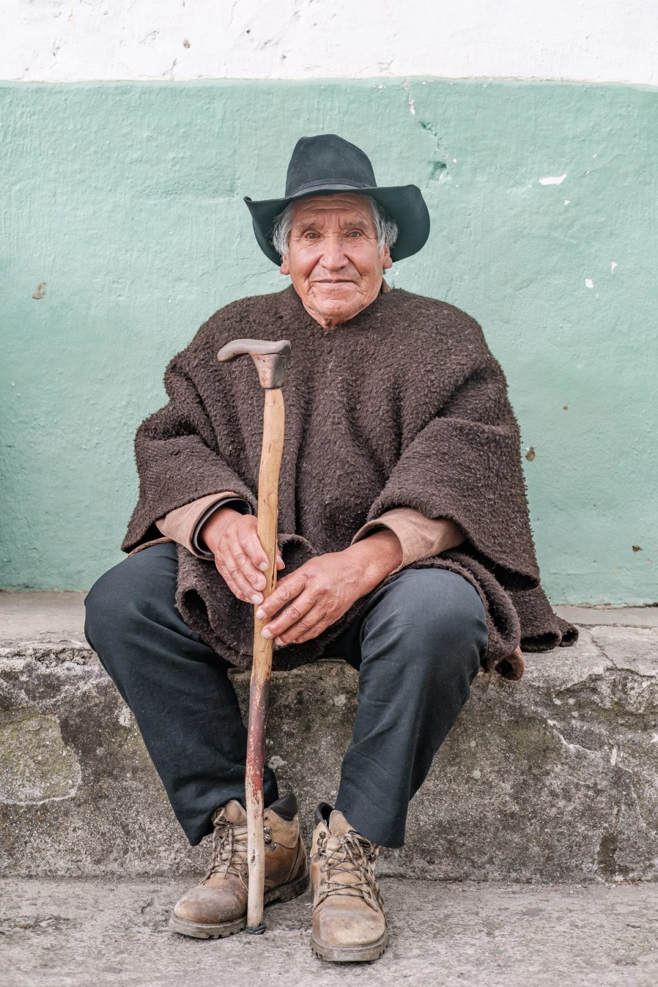 Older man sitting with a walking stick