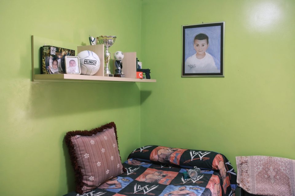 Green bedroom with football memorabilia and family photographs