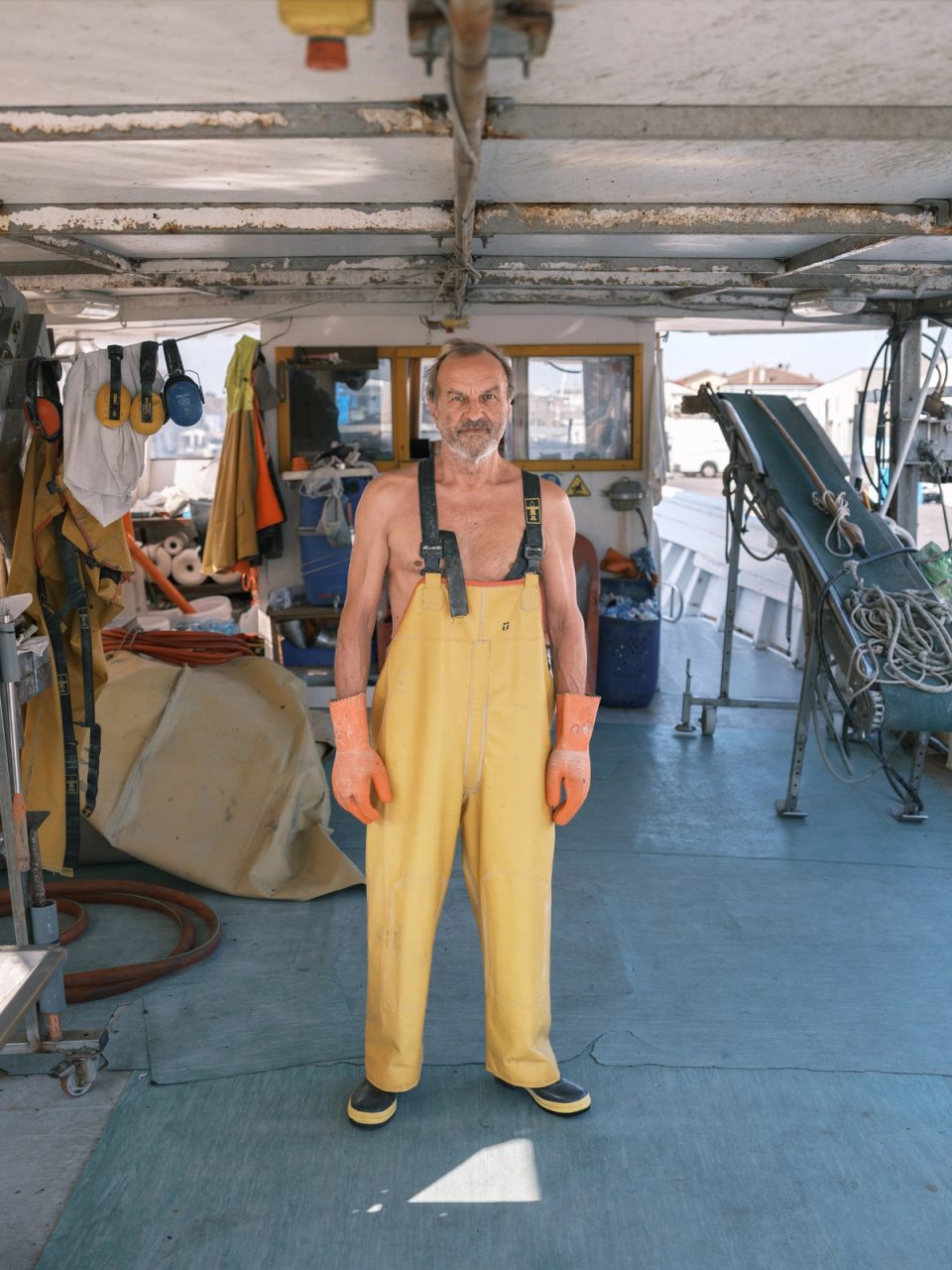 Fisherman wearing yellow overalls at work