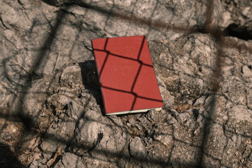 Red Spanish passport lying on rocks