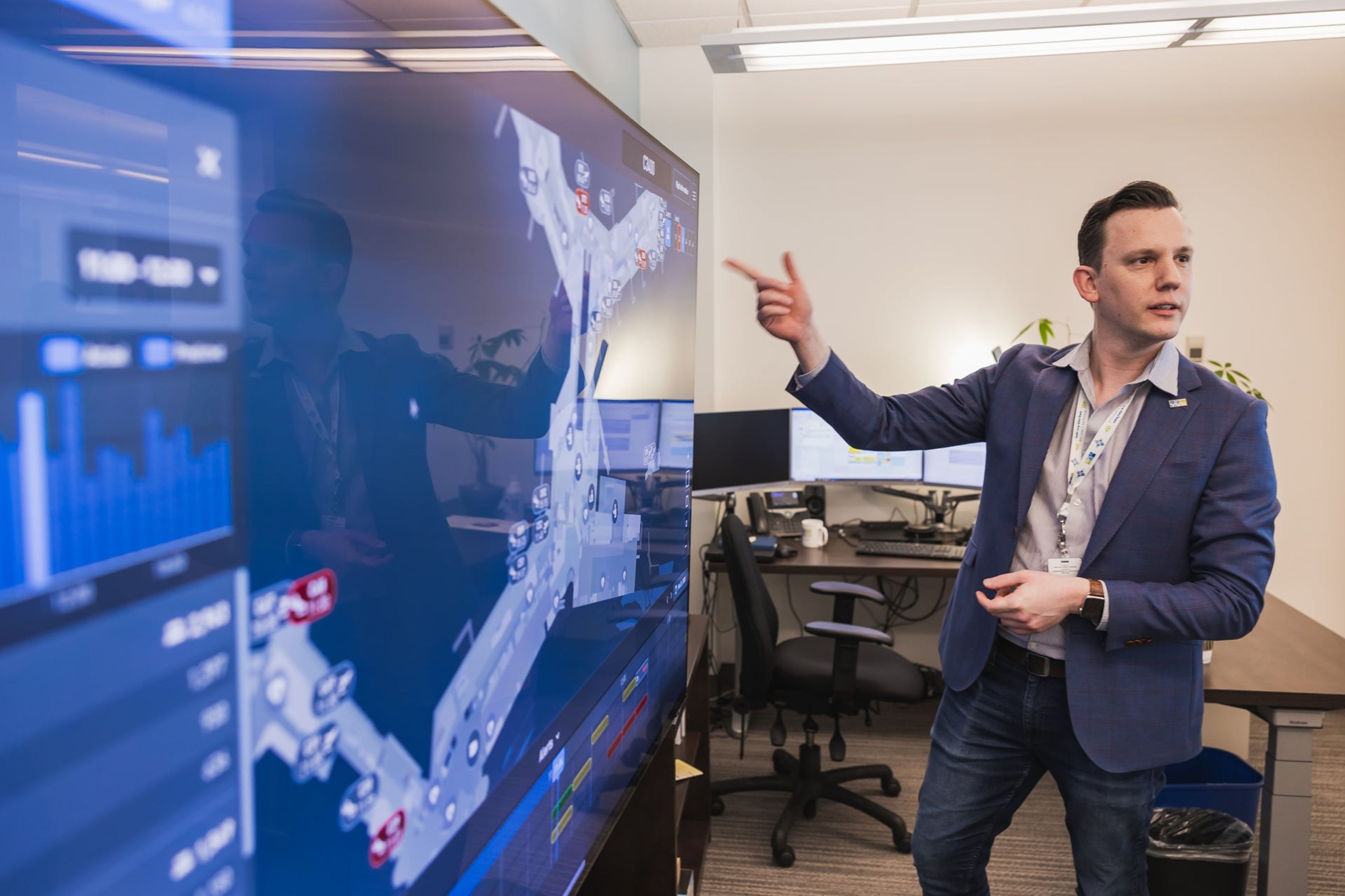 A man presenting a 3d view of the airport on a TV screen