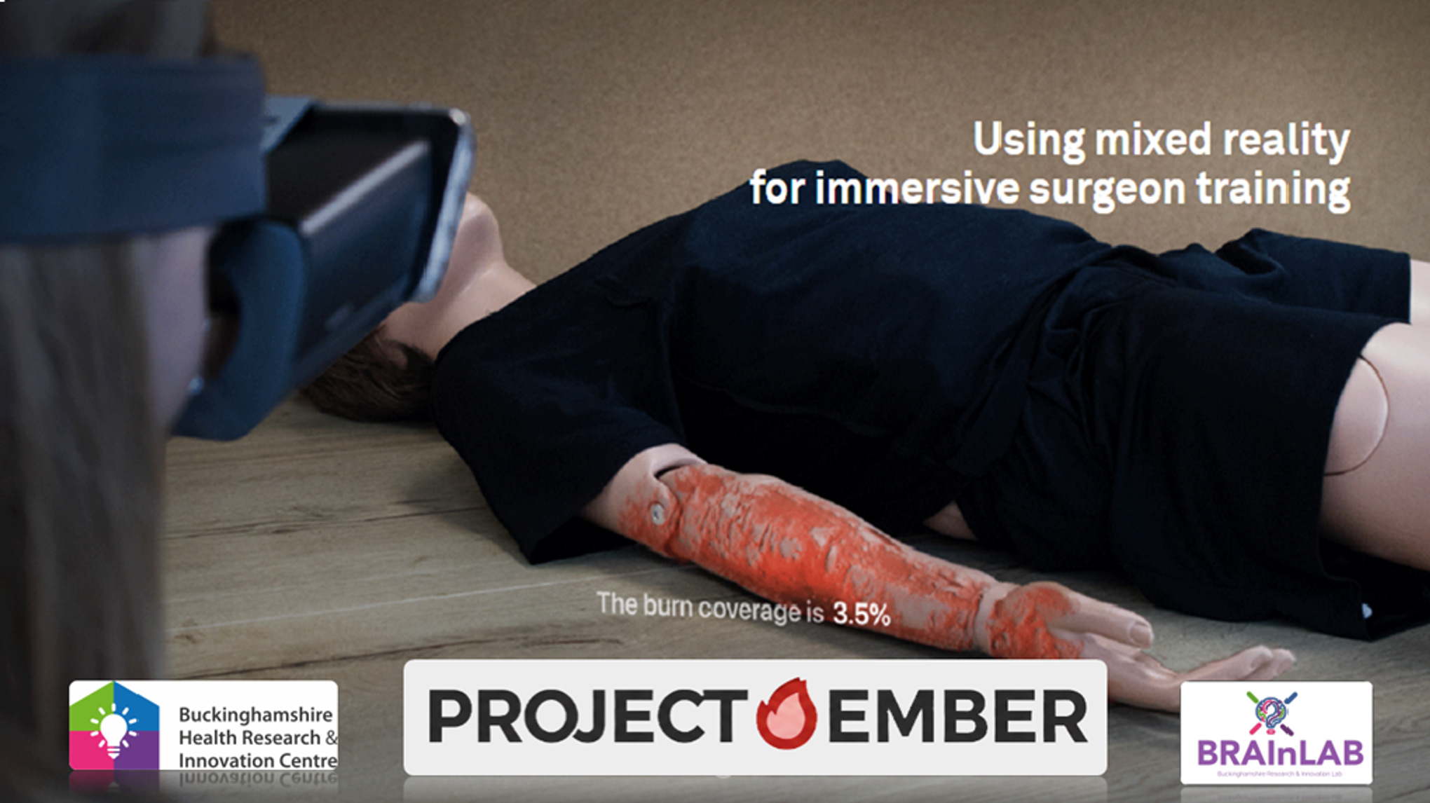 “Project Ember”项目横幅广告展示了一名正在进行混合现实培训的人员,该人员正在观察医疗模拟人手臂上模拟的3.5%烧伤创面,用于外科医生的培训。