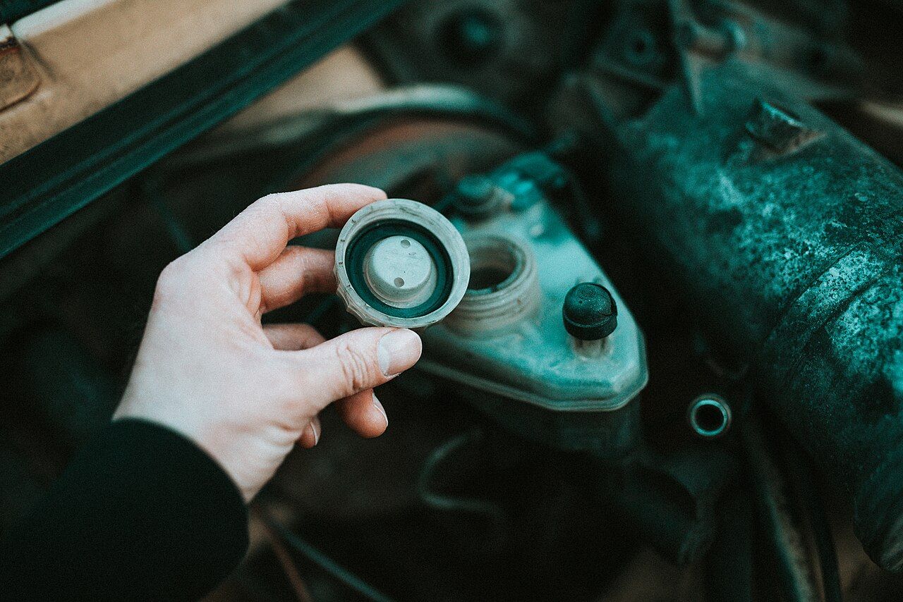 Checking a fluid reservoir during car maintenance; general illustration