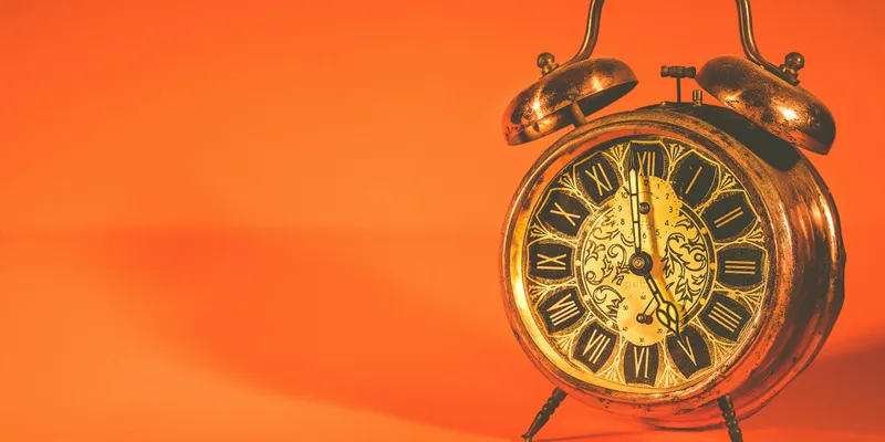 Vintage alarm clock on orange background