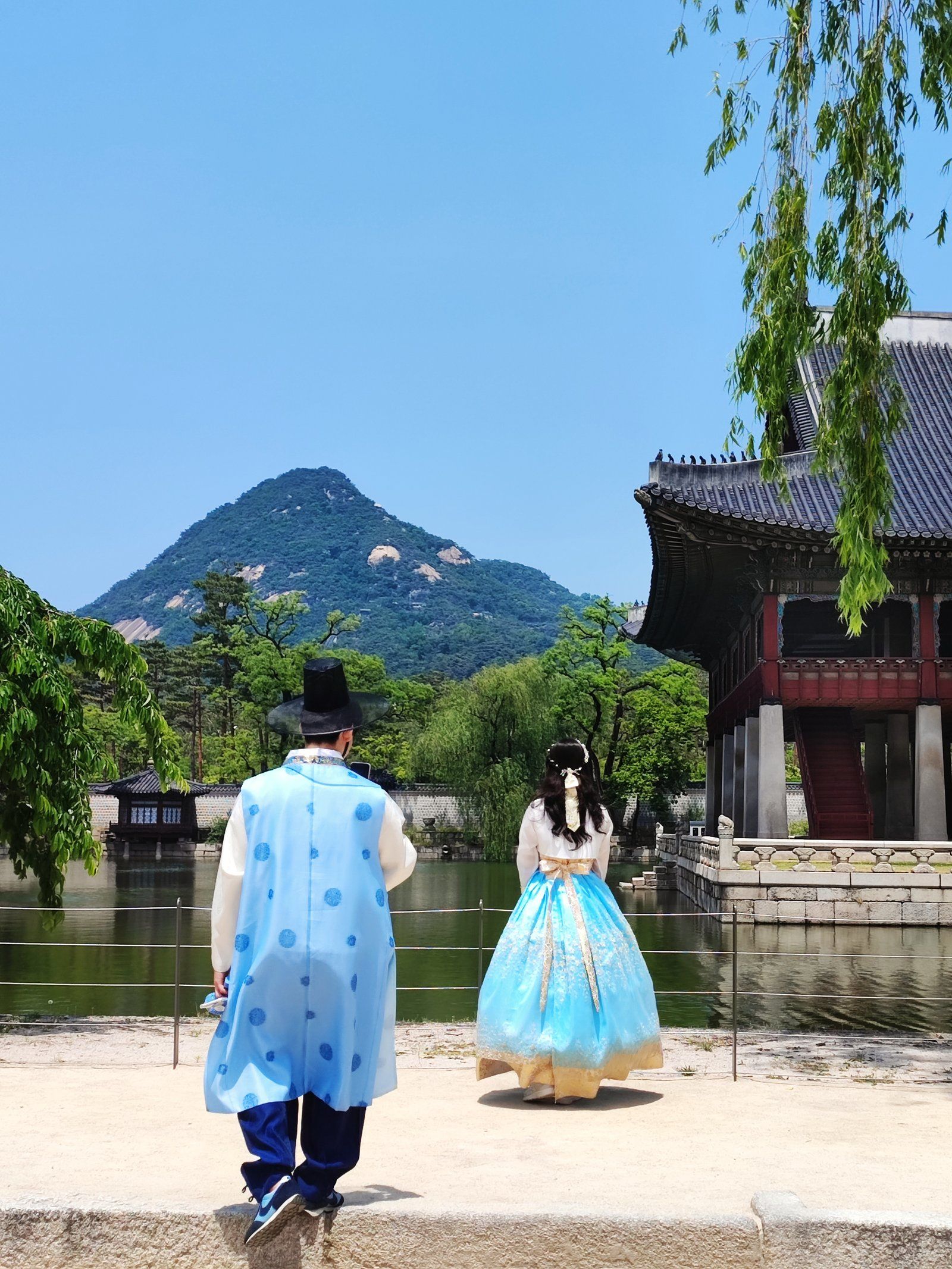 Một đôi nam nữ mặc hanbok dạo trong khuôn viên cung Gyeongbokgung
