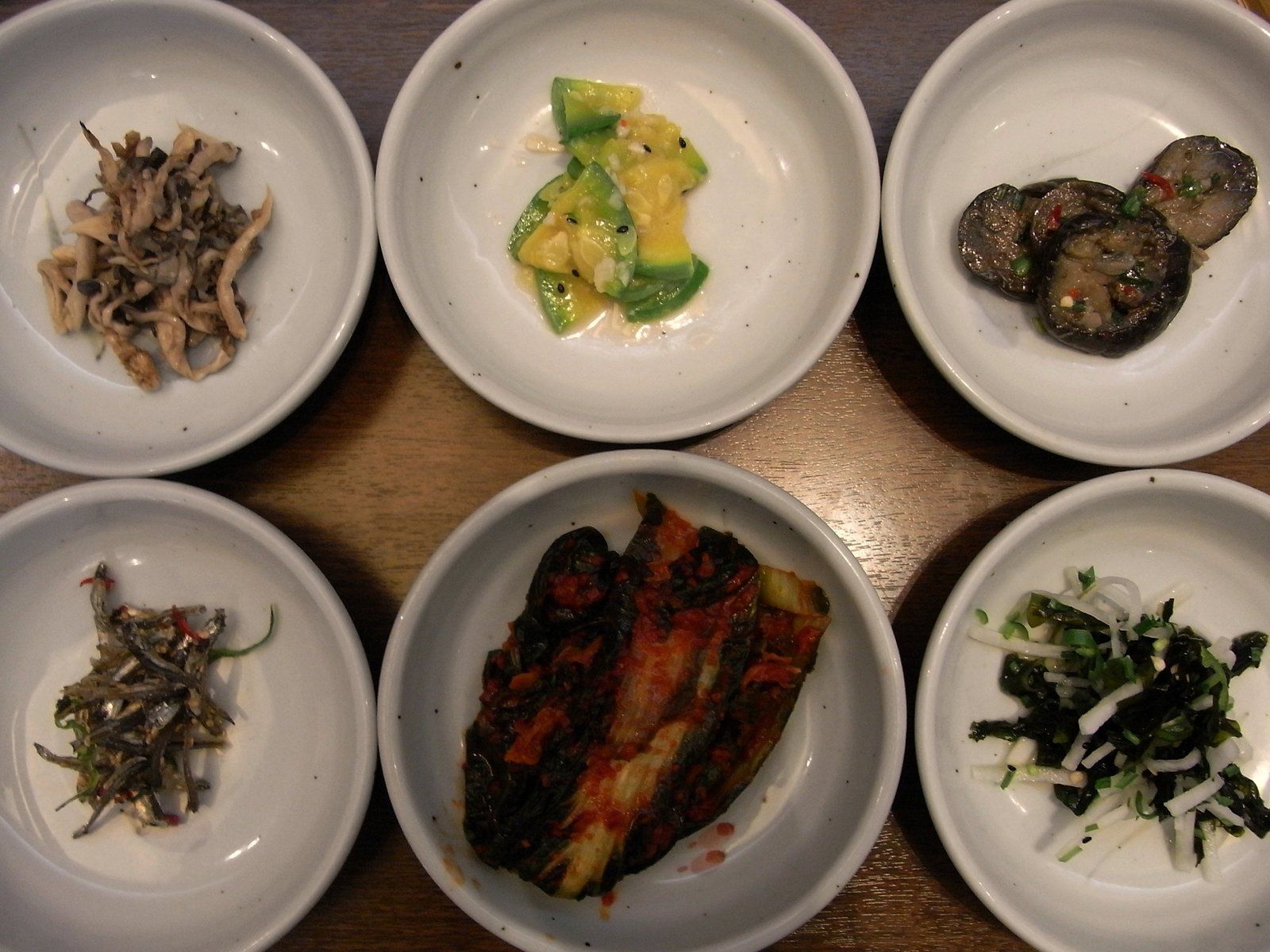 Sáu đĩa món phụ banchan quanh bàn ăn Hàn Quốc