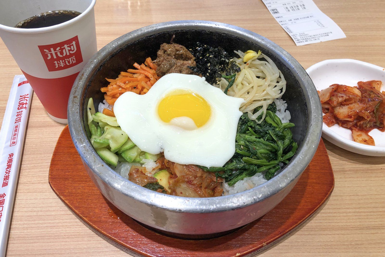 Tô cơm trộn bibimbap dọn trên bàn ăn Hàn