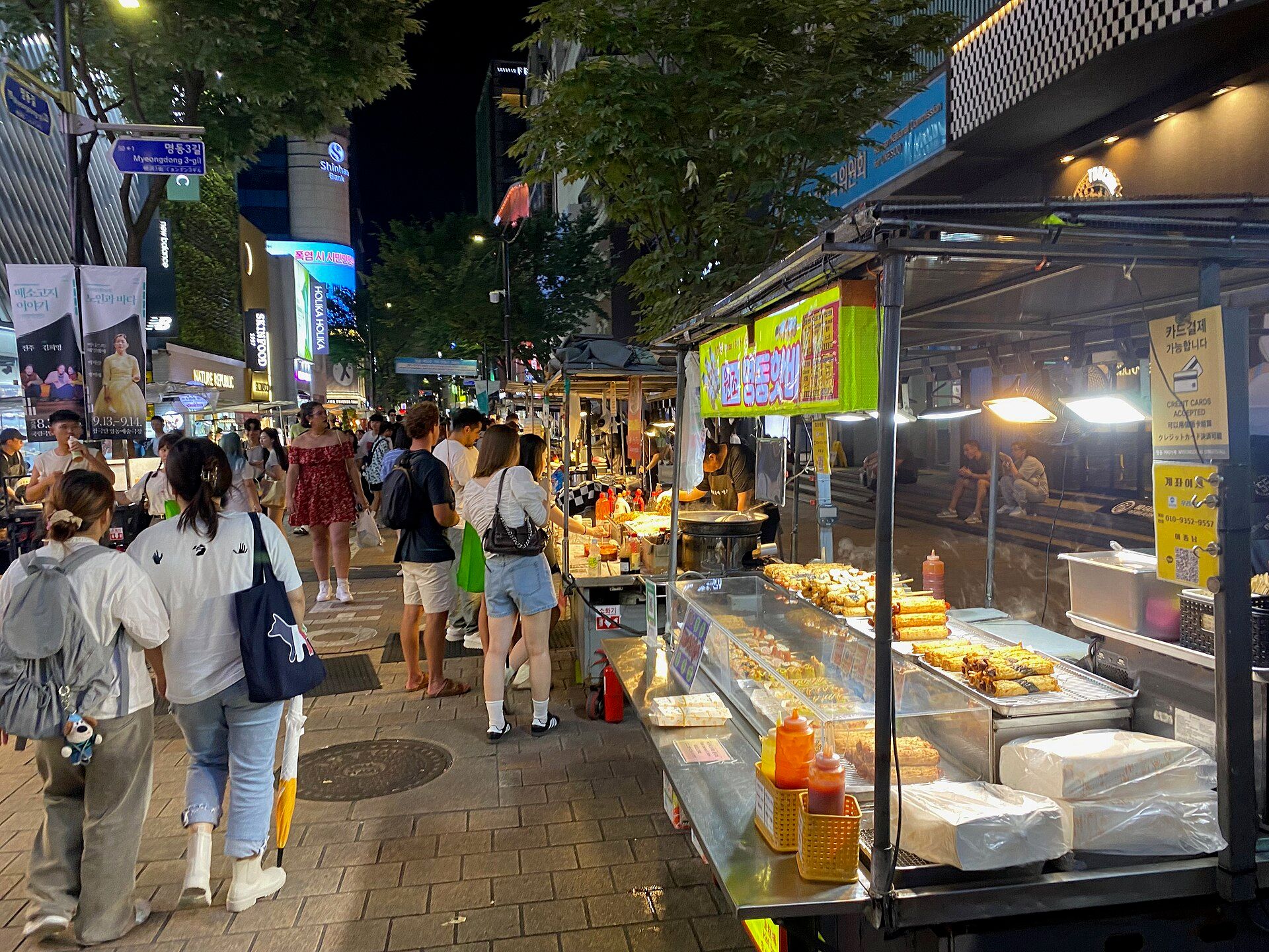 Phố chợ đêm Myeongdong (명동) Seoul rực biển hiệu — nơi đầy từ Konglish