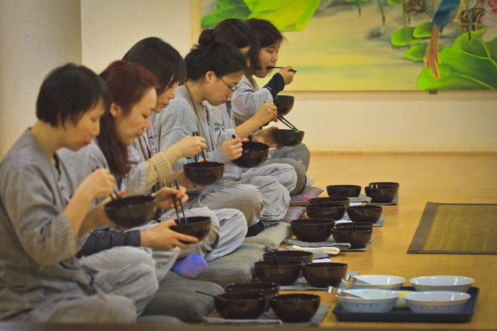 Những người tham gia templestay trong áo tu tập màu xám dùng bữa cơm chay bằng bát gỗ
