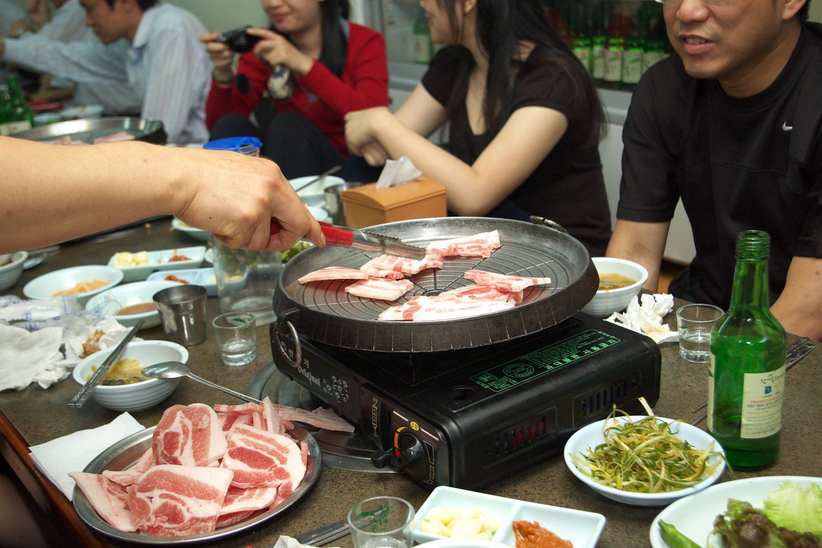 Bàn ăn samgyeopsal với vỉ nướng và món phụ