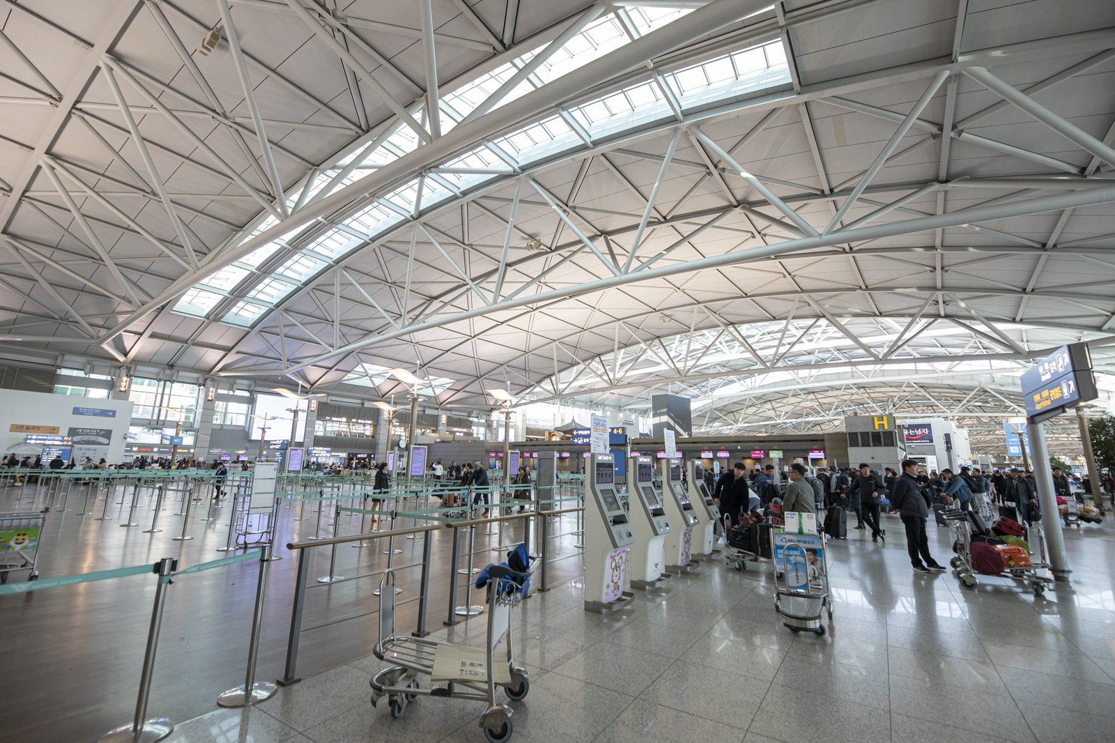 Sảnh khởi hành rộng lớn của Sân bay Quốc tế Incheon với hành khách kéo vali