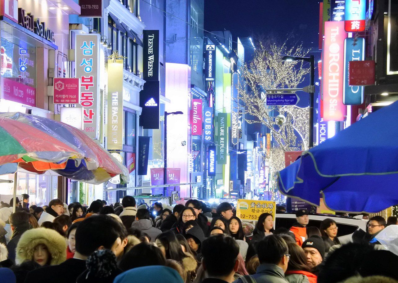 Dòng người chen chúc trên phố mua sắm Myeongdong rực ánh đèn