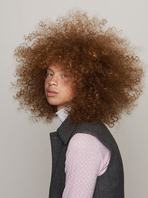 Model with glossy, defined copper curls