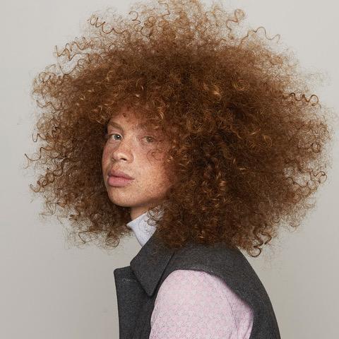 Model with glossy, defined copper curls