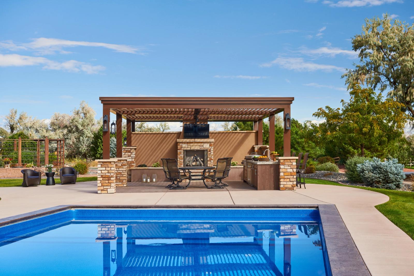 poolside outdoor kitchen in dark finish with outdoor fireplace