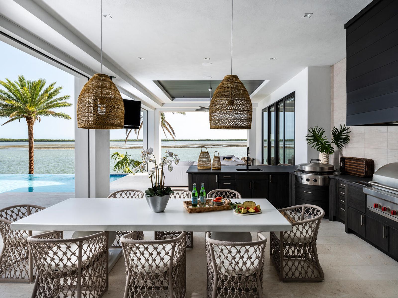 Open-air lanai kitchen in charcoal cabinetry with built-in grill