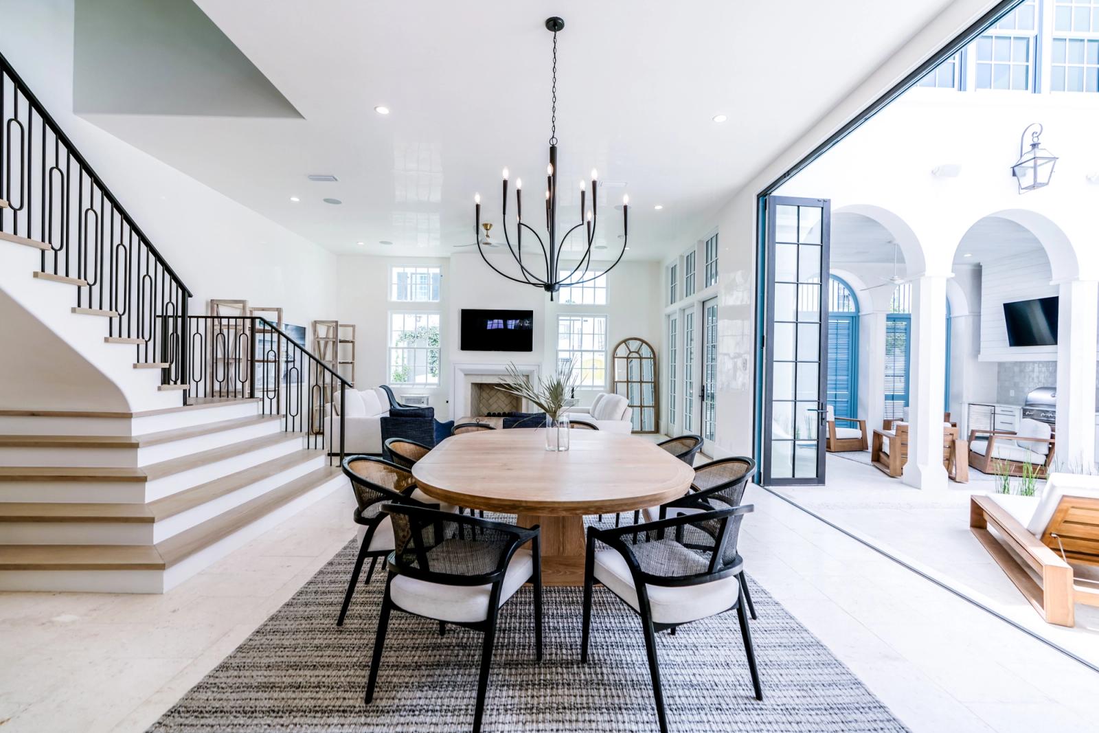 dining room with open doors to outdoor kitchen courtyard in alys beach