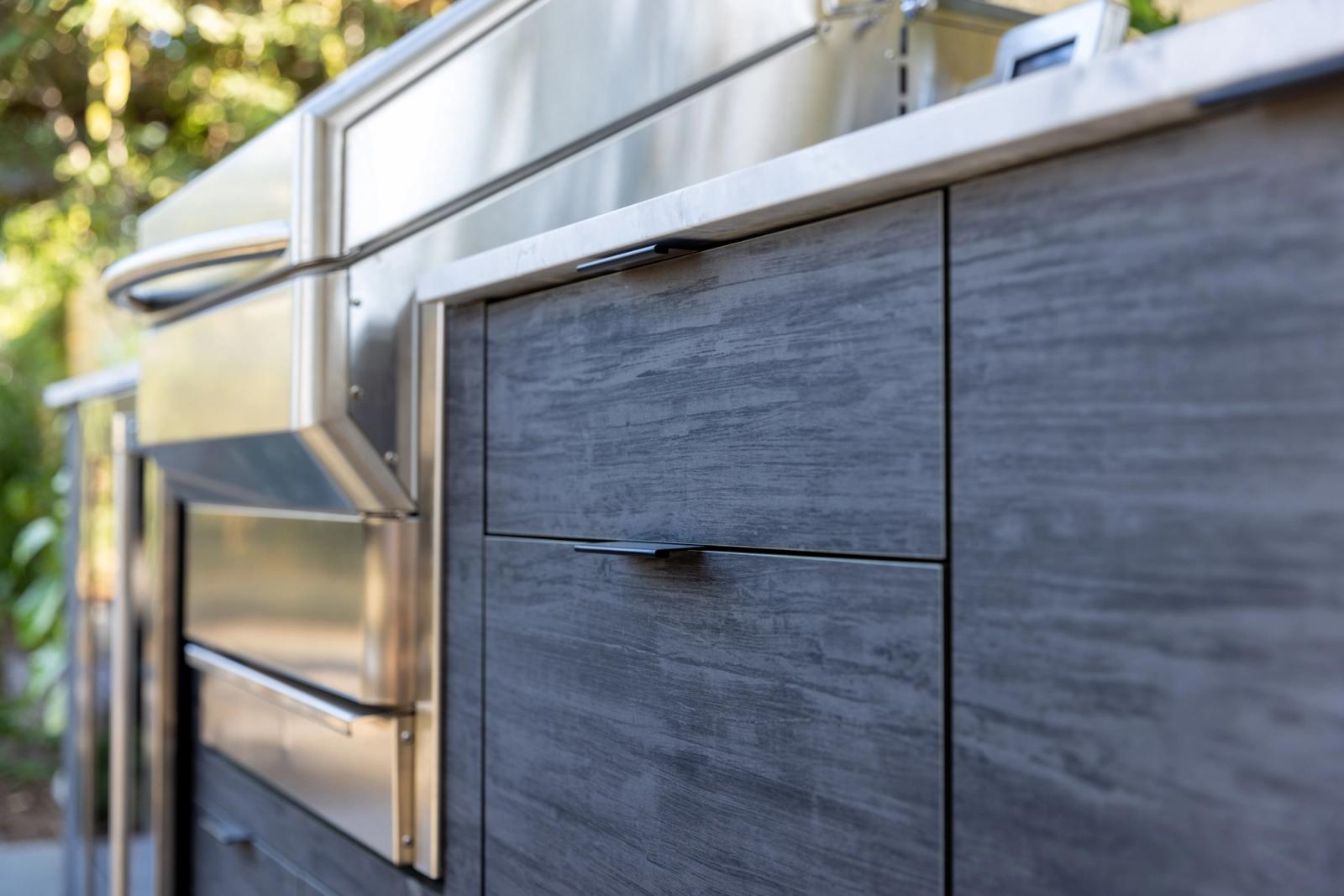 close up of modern slab outdoor kitchen with built in grill