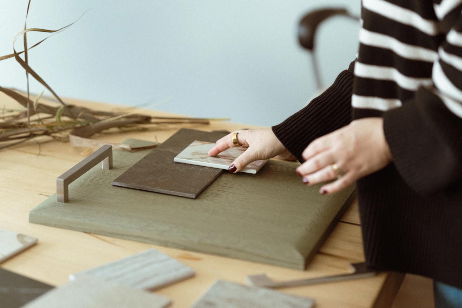 Designer arranging cabinetry and stone samples material board
