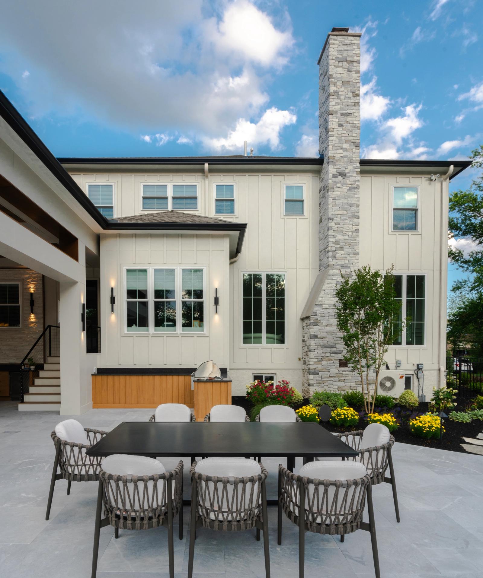 board and batten home with outdoor cabinets and built in grill