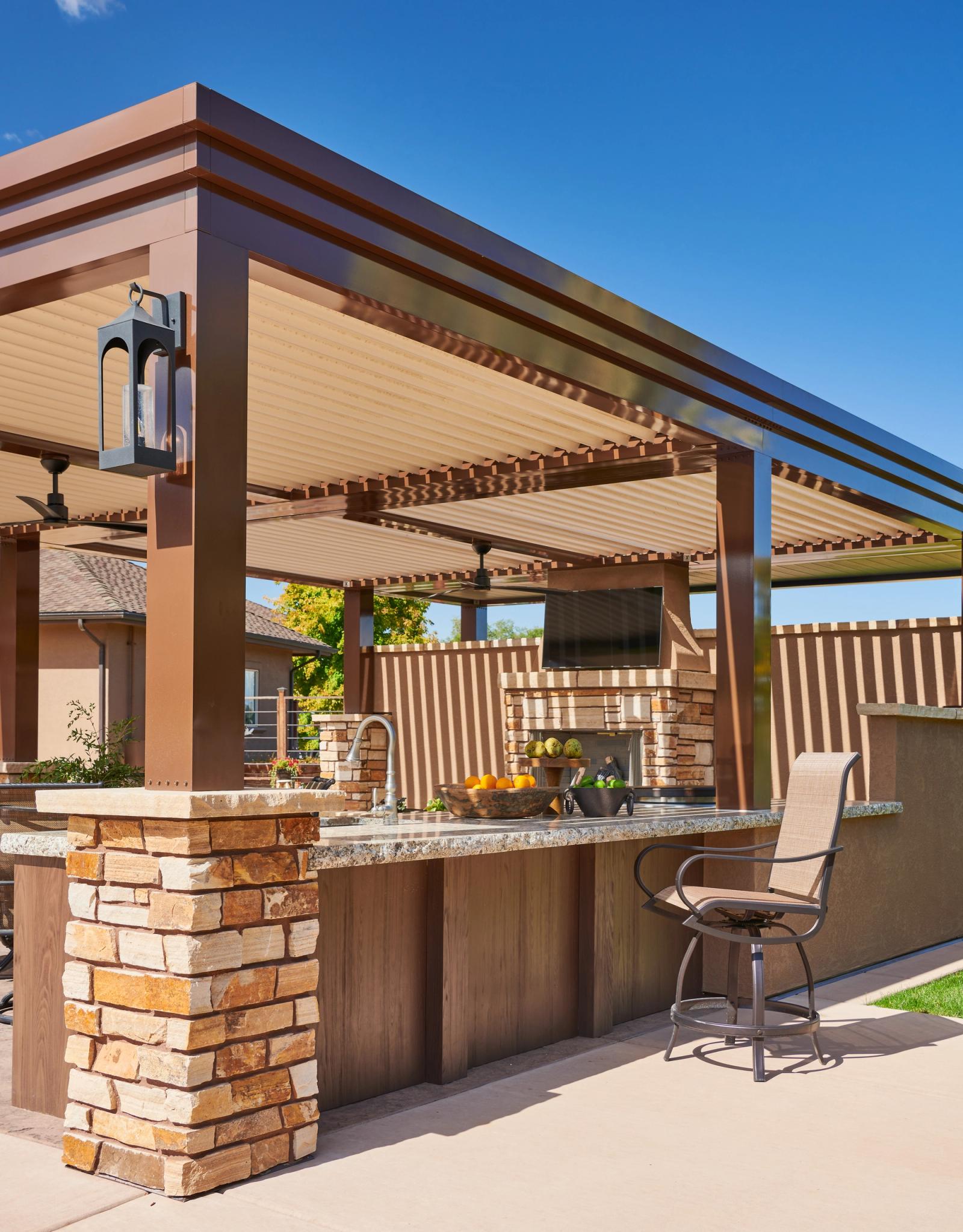 Louvered pergola over a outdoor kitchen in colorado