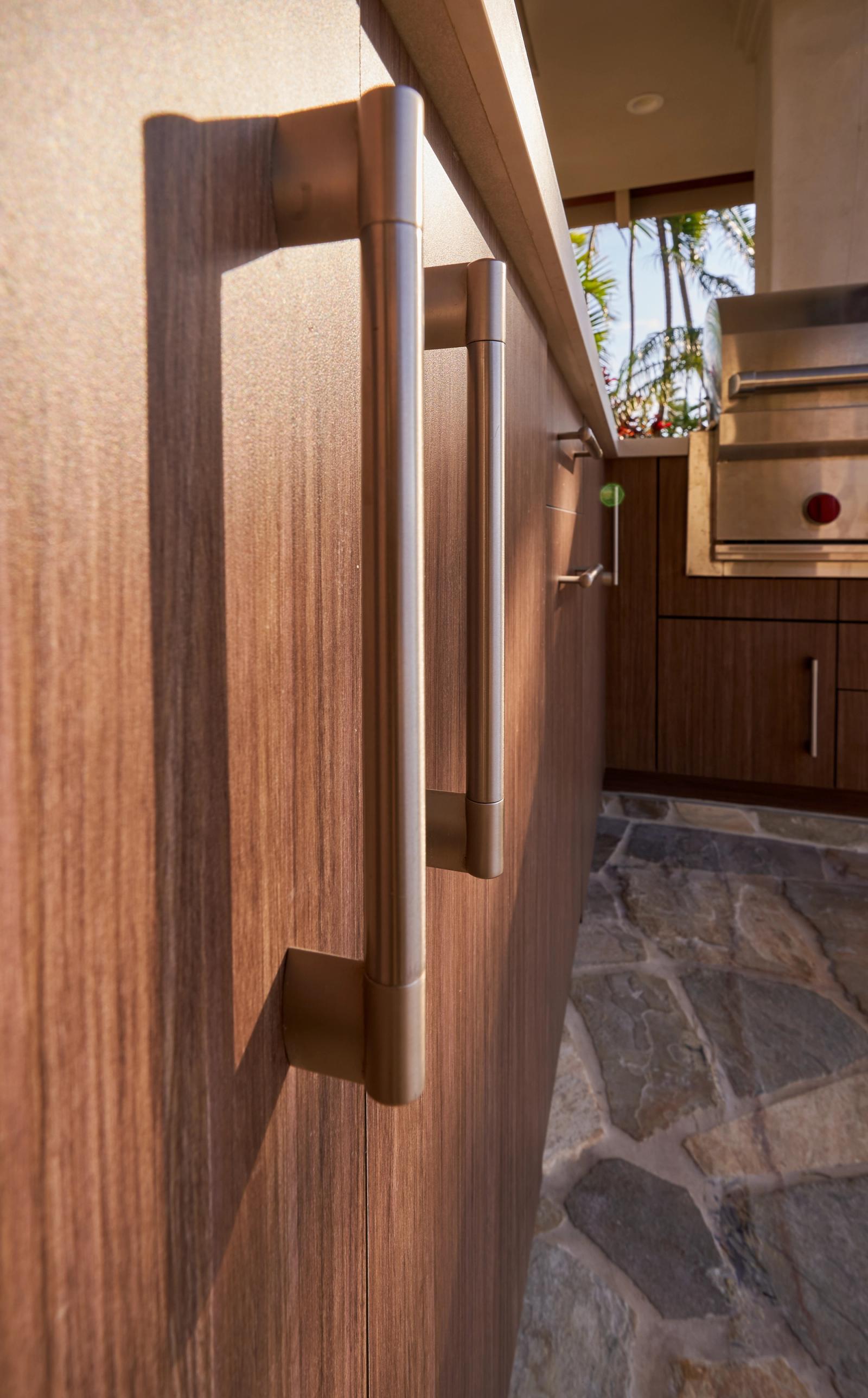 close up of walnut toned cabinet doors and stainless steel handles