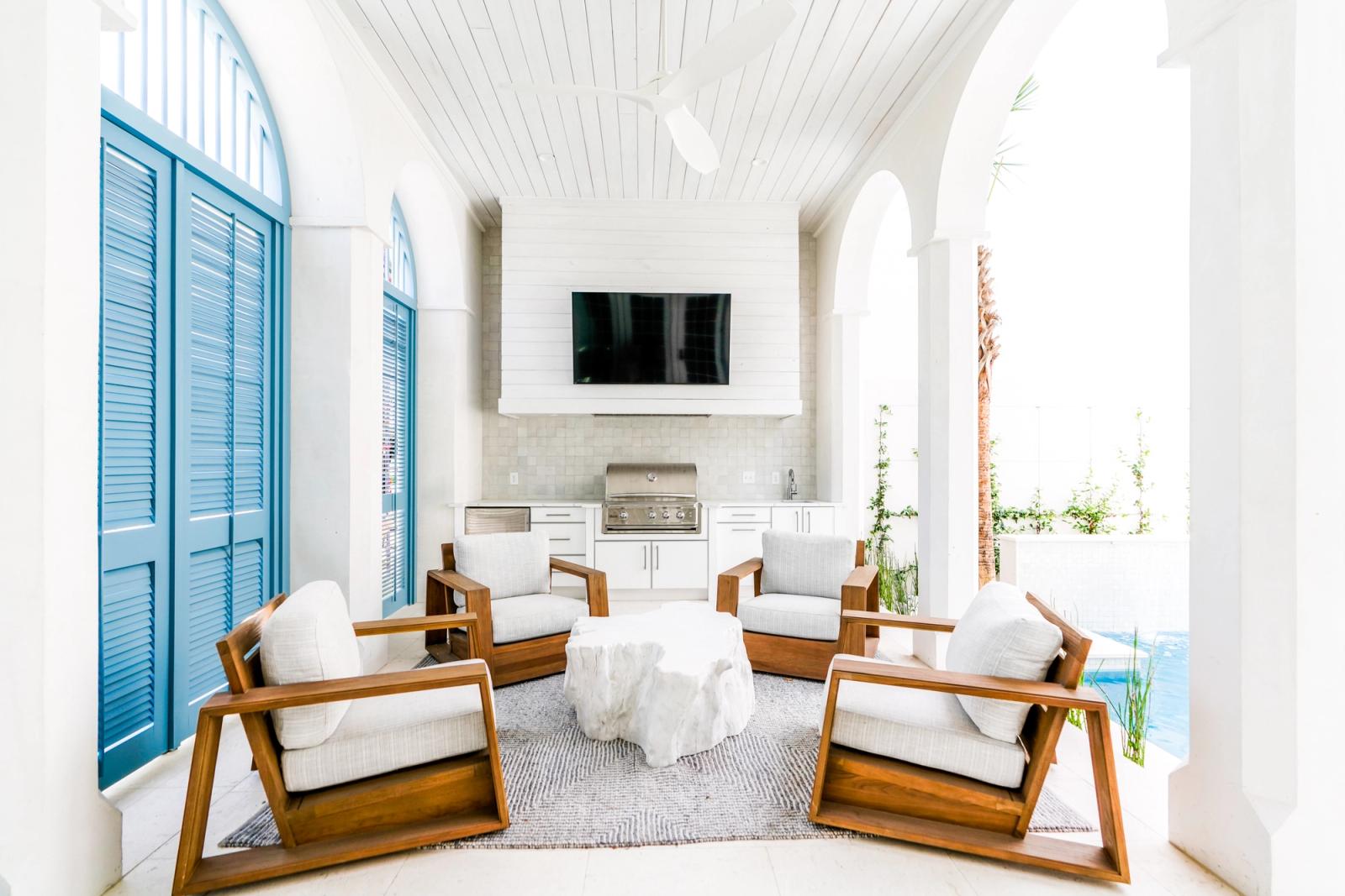 White lanai with blue louvered shutters and contempo outdoor kitchen