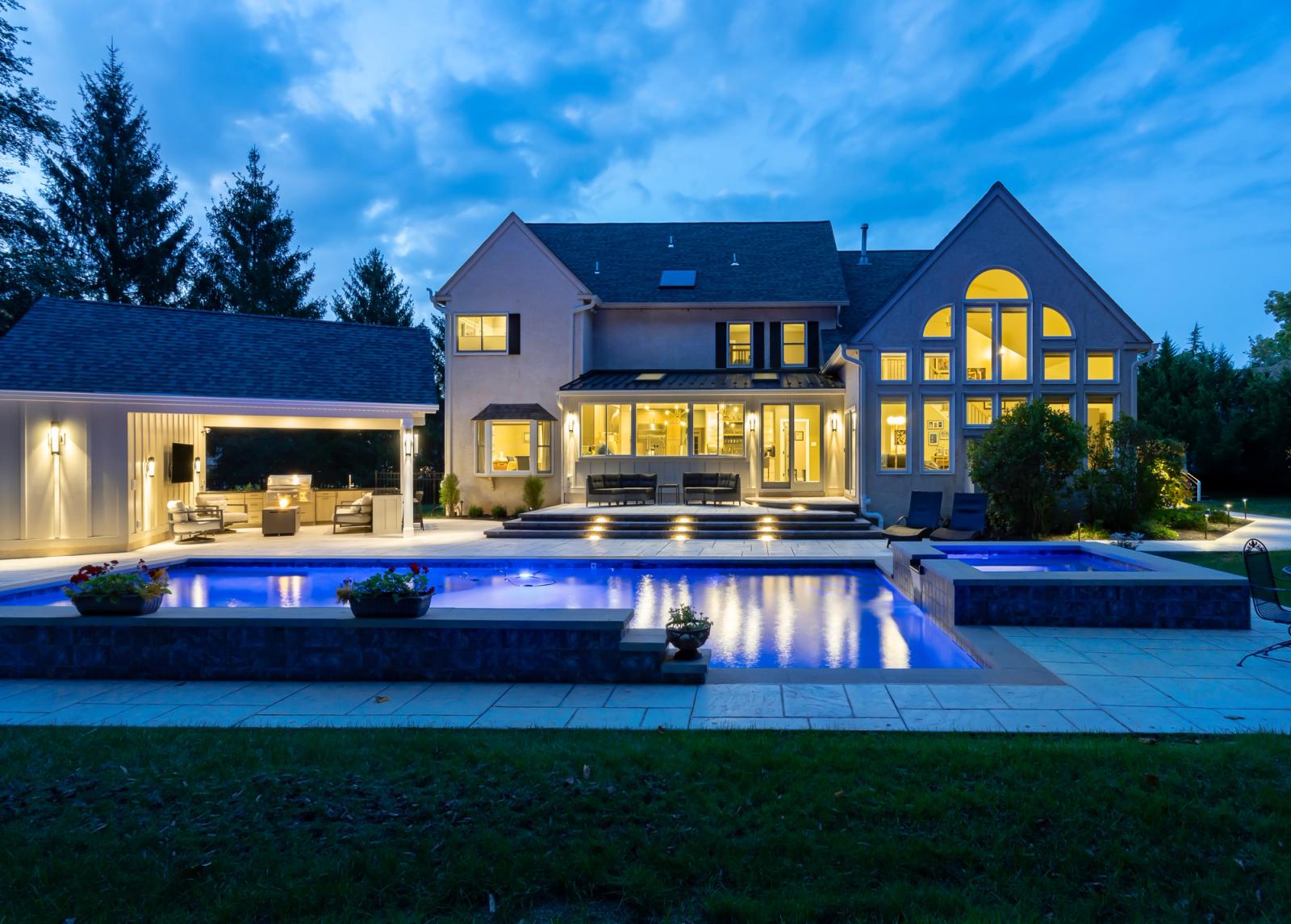backyard pool and covered patio kitchen at dusk in pennsylvania