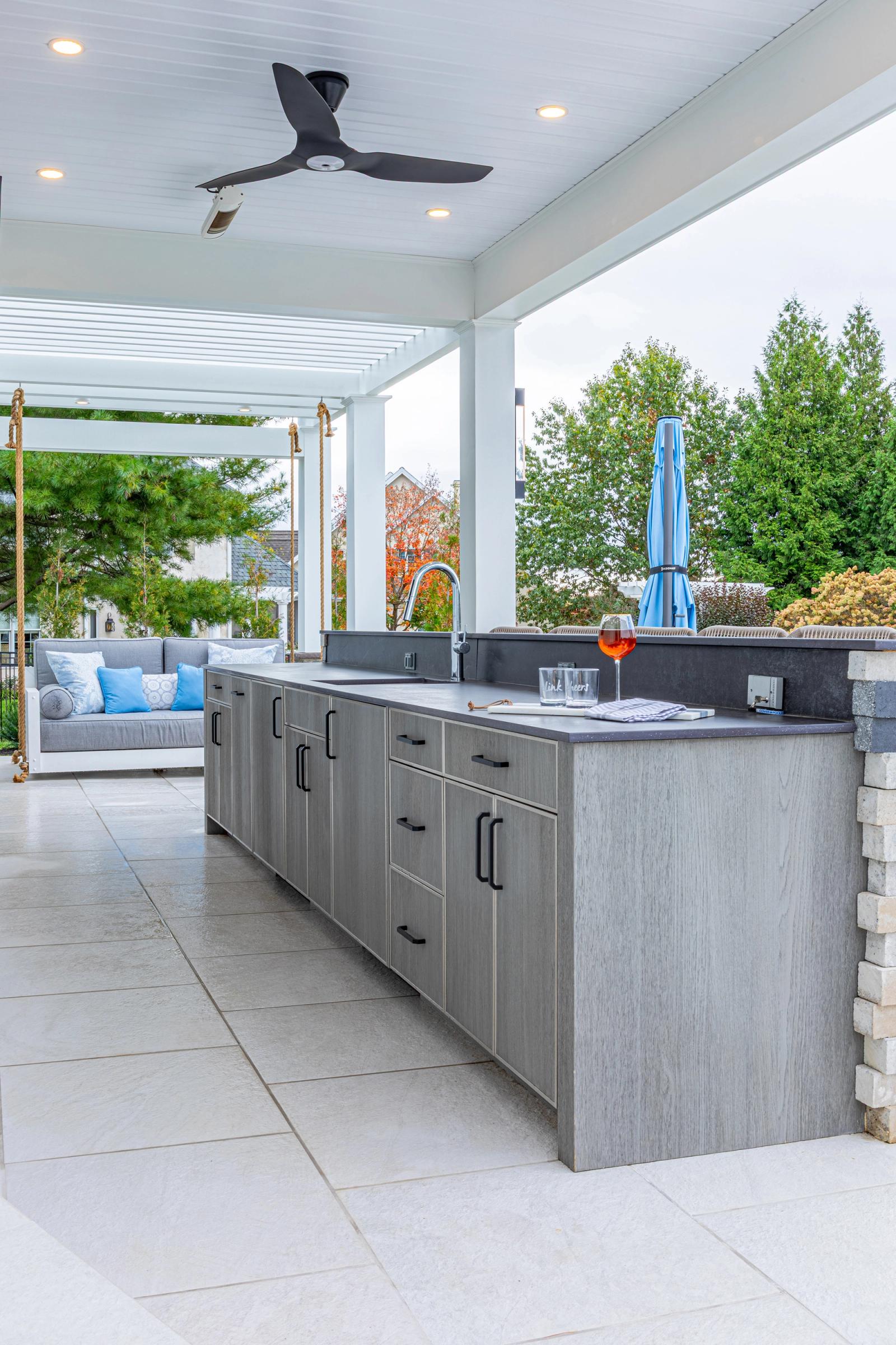 woodgrain outdoor cabinetry run with a sink