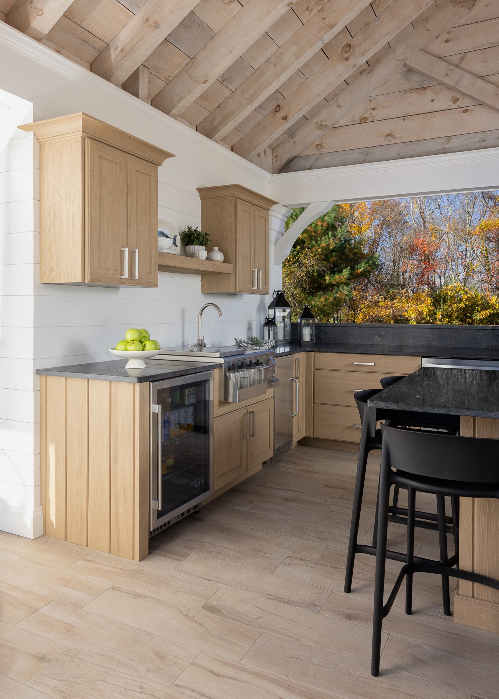 natural blonde outdoor kitchen with dark stone counters and beverage centre