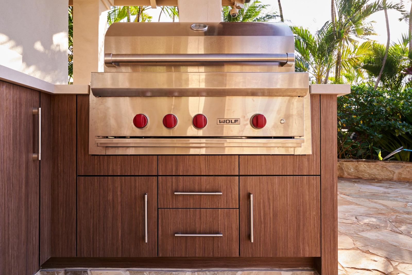 outdoor woodgrain cabinetry with a large built-in stainless grill