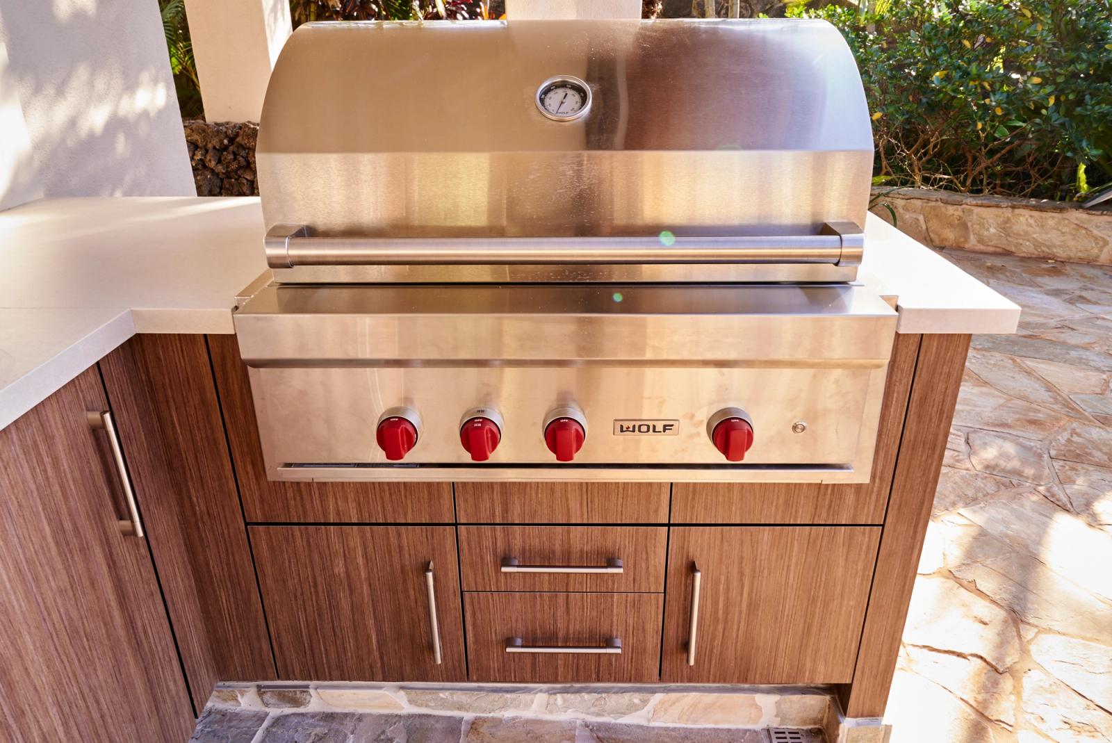 Ocean front built-in stainless grill set in walnut-toned woodgrain cabinetry
