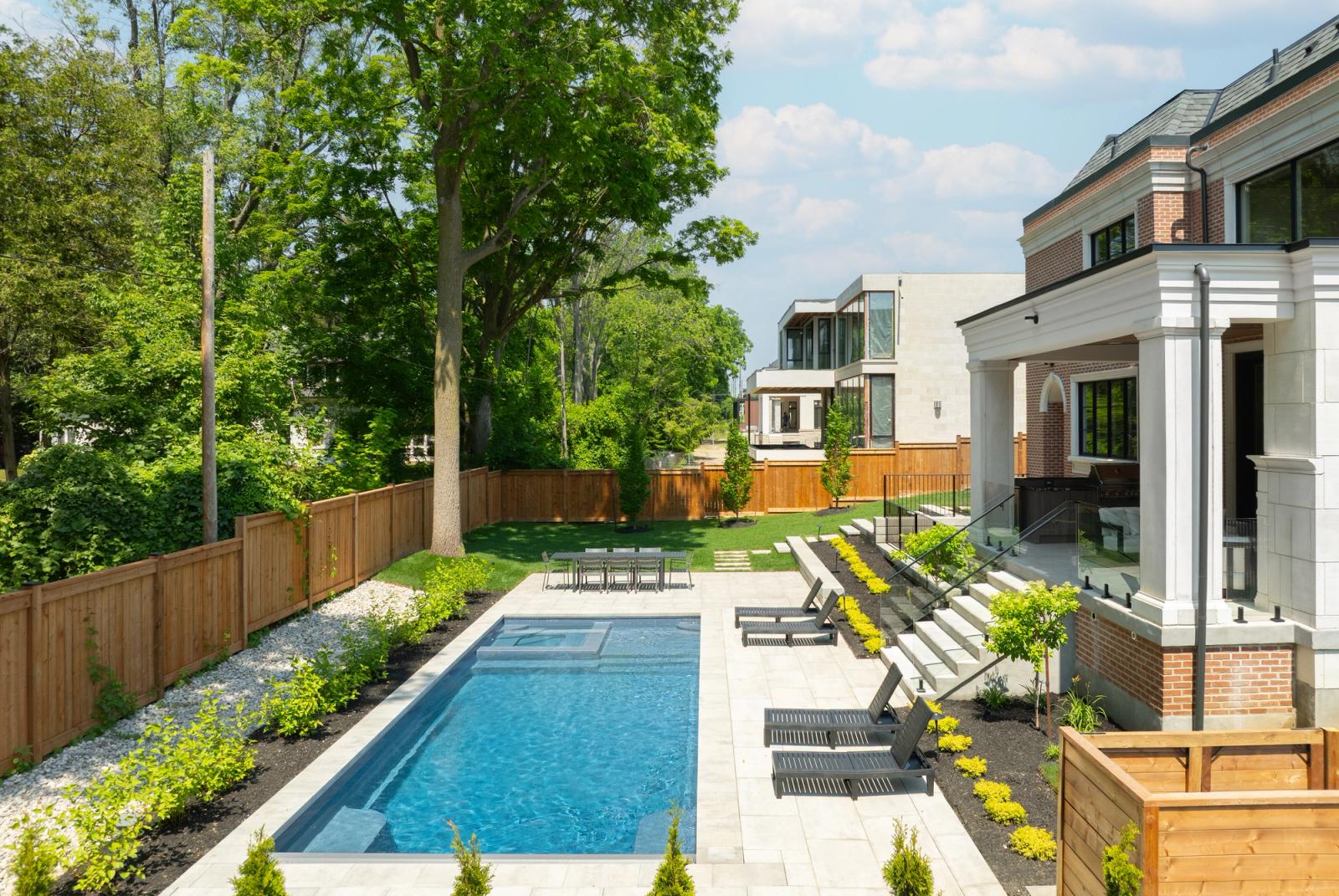 Long backyard pool with a covered kitchen in oakville ontario