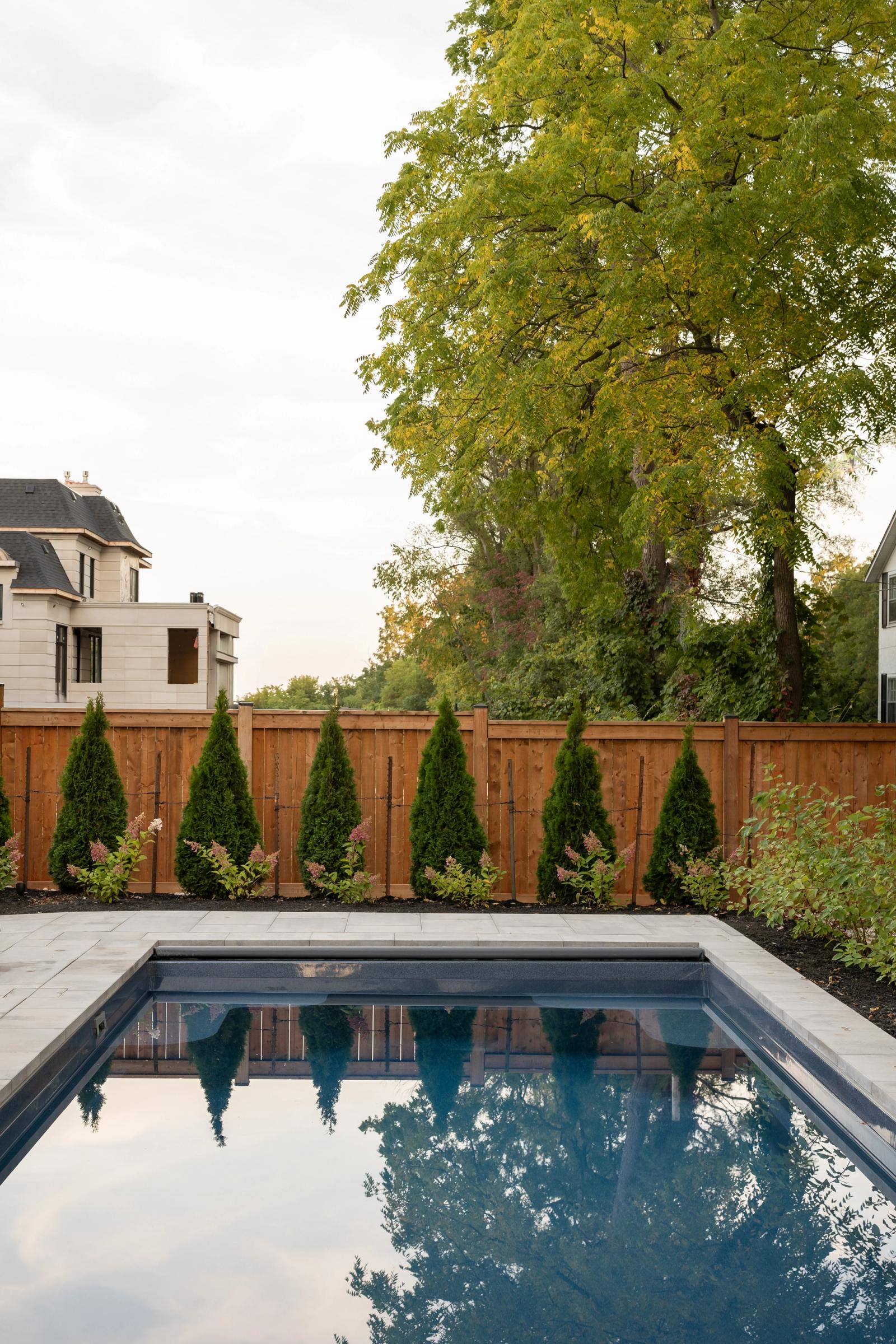 outdoor kitchen near rectangular pool edged in stone