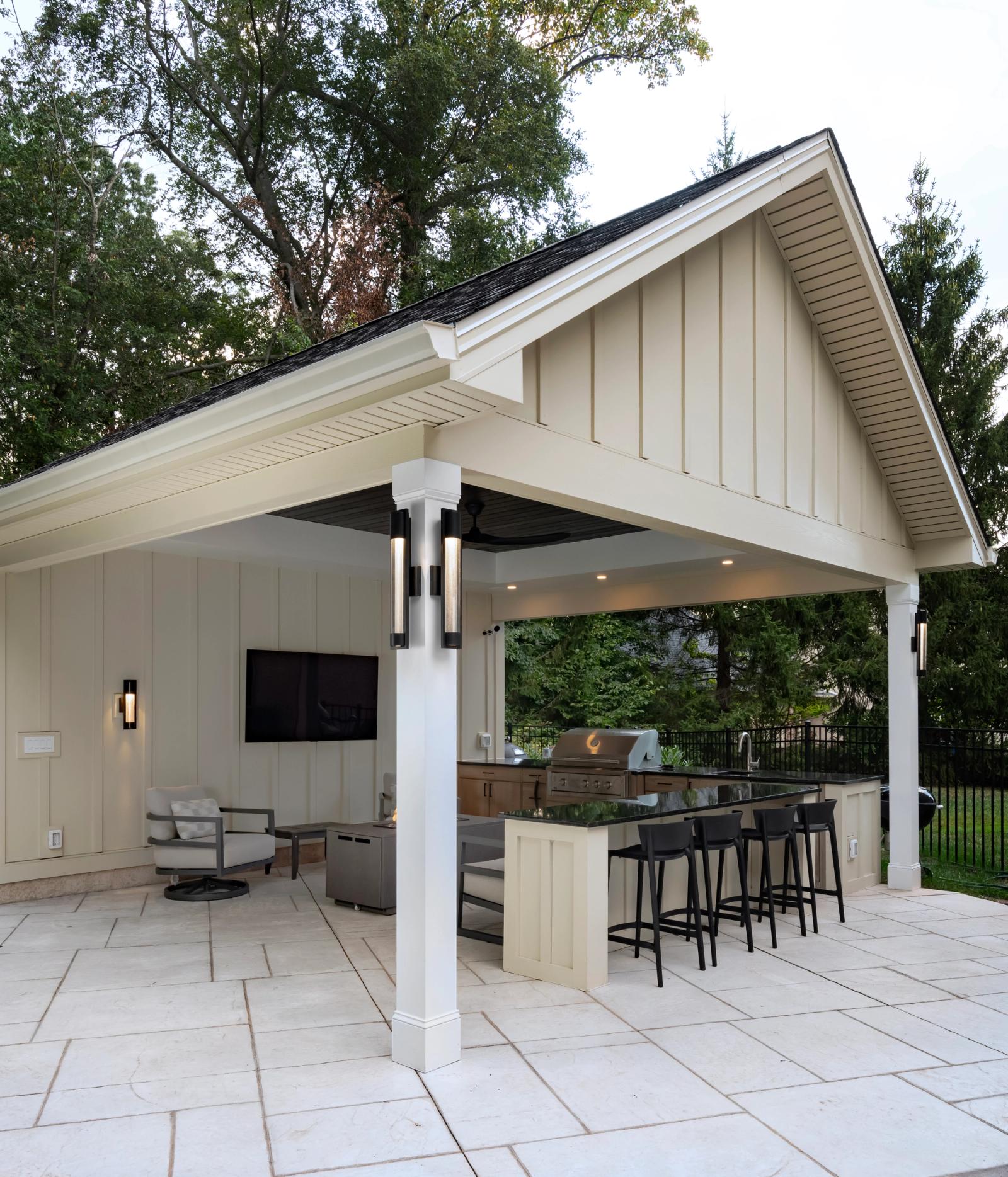 Covered poolhouse outdoor kitchen with a bar-height island