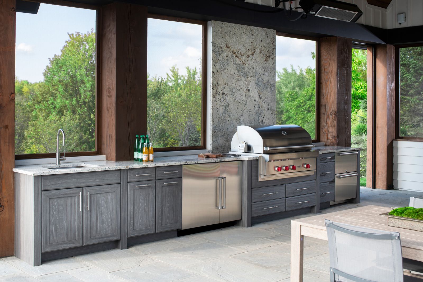 grey finish outdoor kitchen set in pavillion with view of trees
