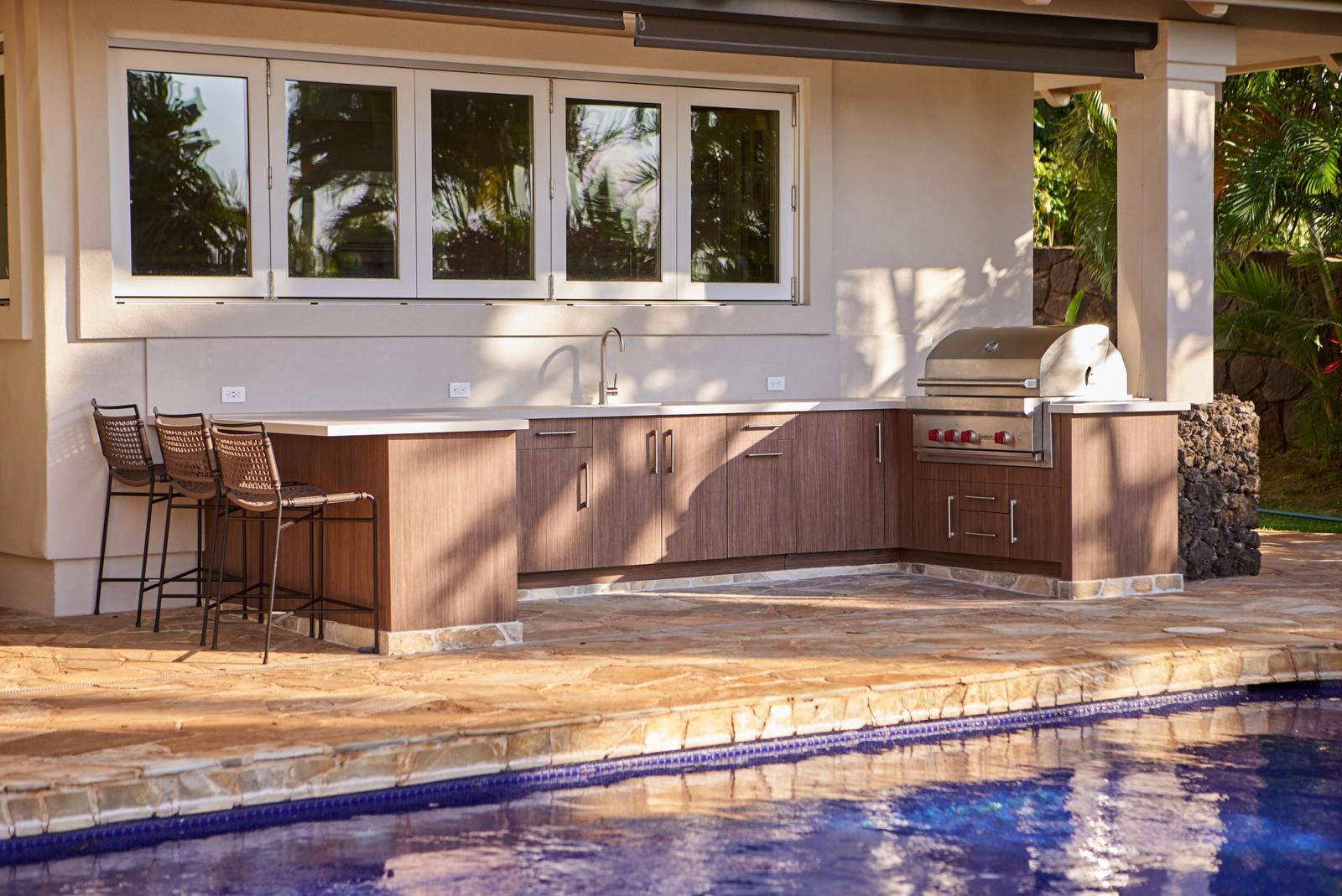 Poolside lanai kitchen in Hawaii with walnut-toned cabinetry