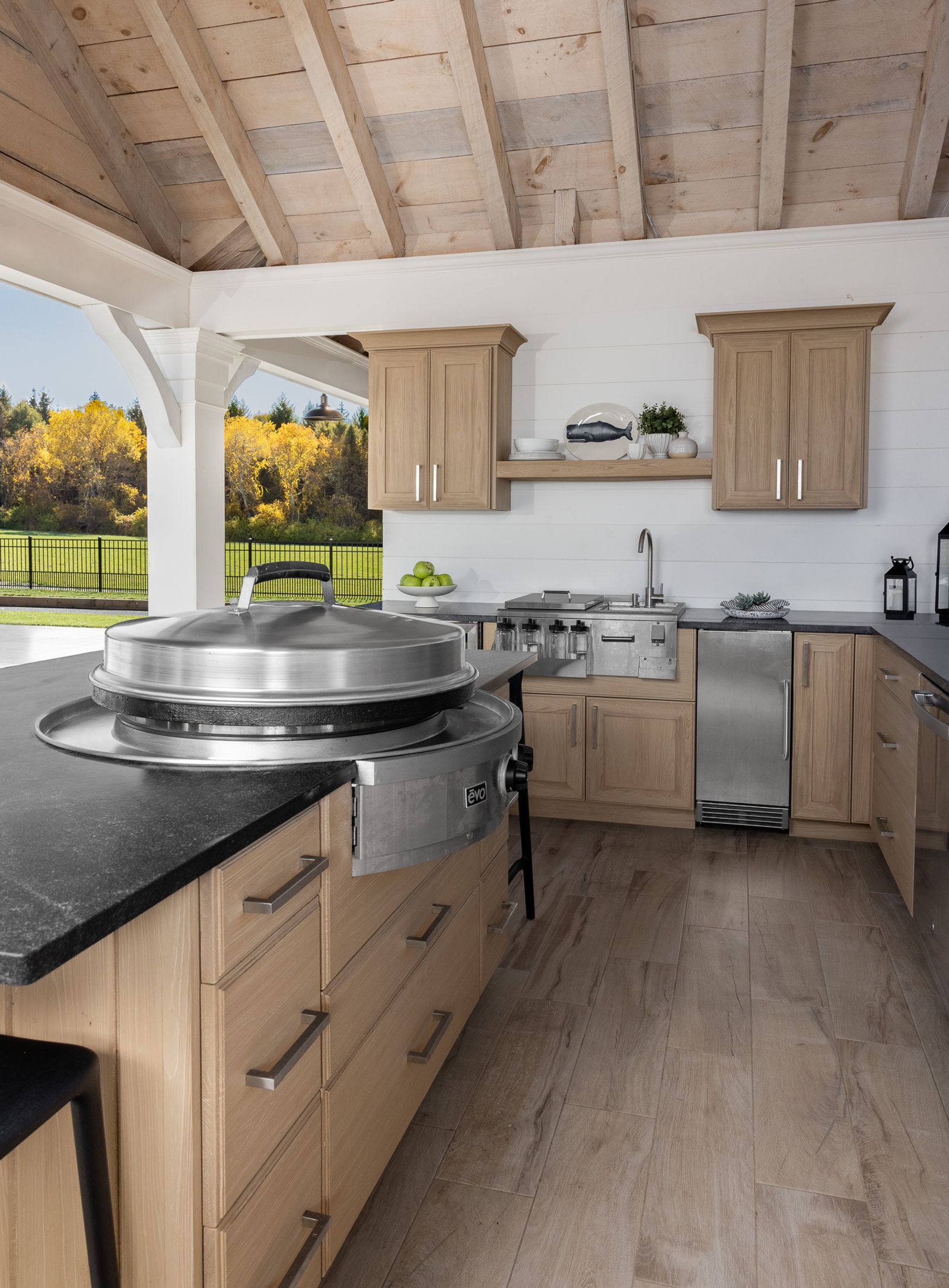 Pavilion outdoor kitchen in oak cabinetry with a built-in griddle