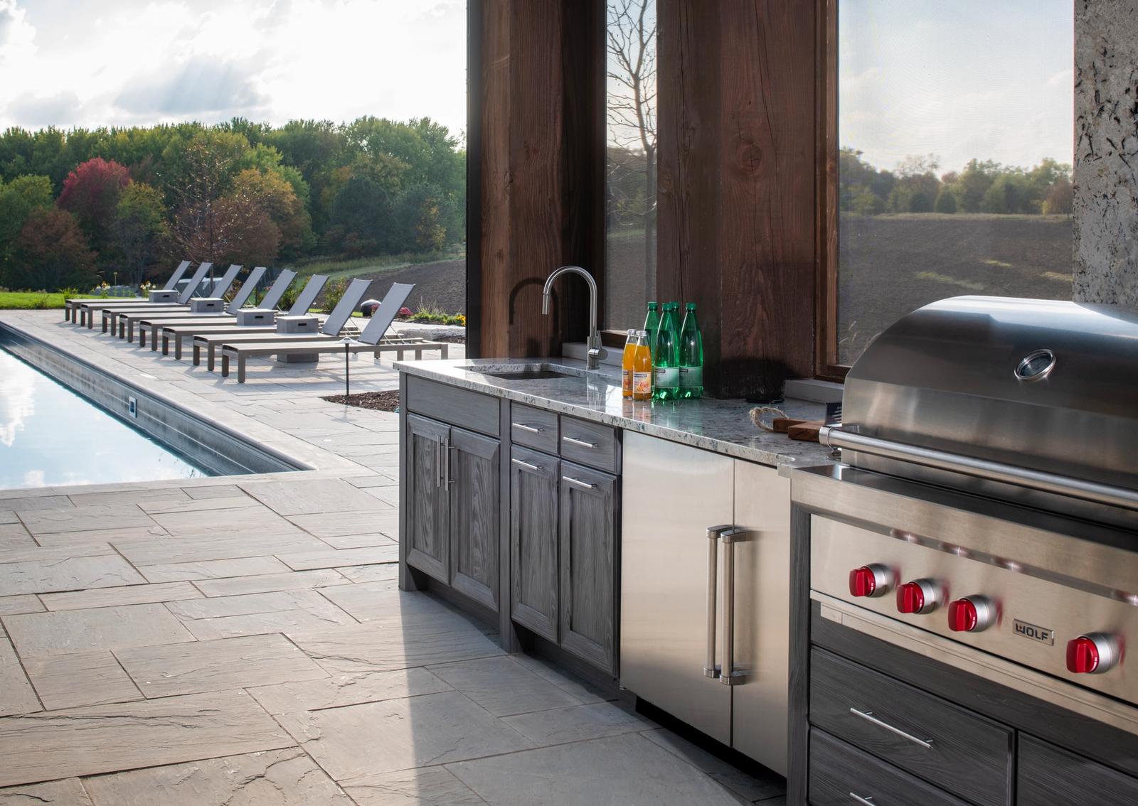 poolside outdoor kitchen in grey finish with pool view