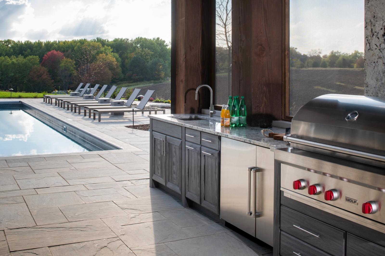 poolside outdoor kitchen in grey finish with pool view