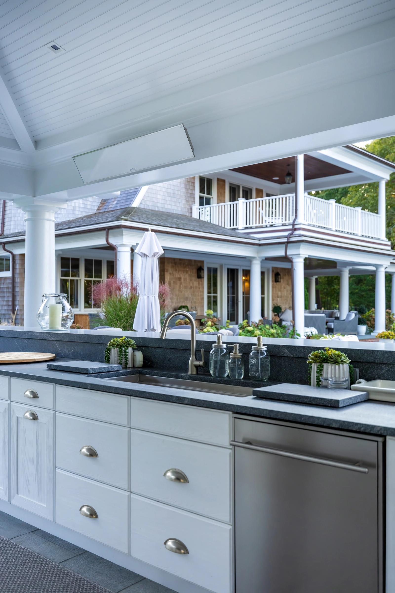 covered outdoor kitchen white cabinetry and sink dishwasher
