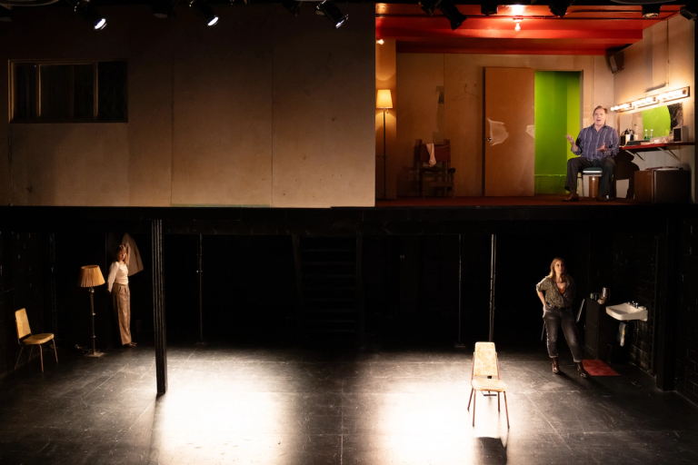 Wide angle shot Heather Raffo and Crystal Finn on lower level of set with Kurt Rhoads on upper level of set all looking out at the audience in Munich Medea Happy Family at PlayCo and WP Theatre