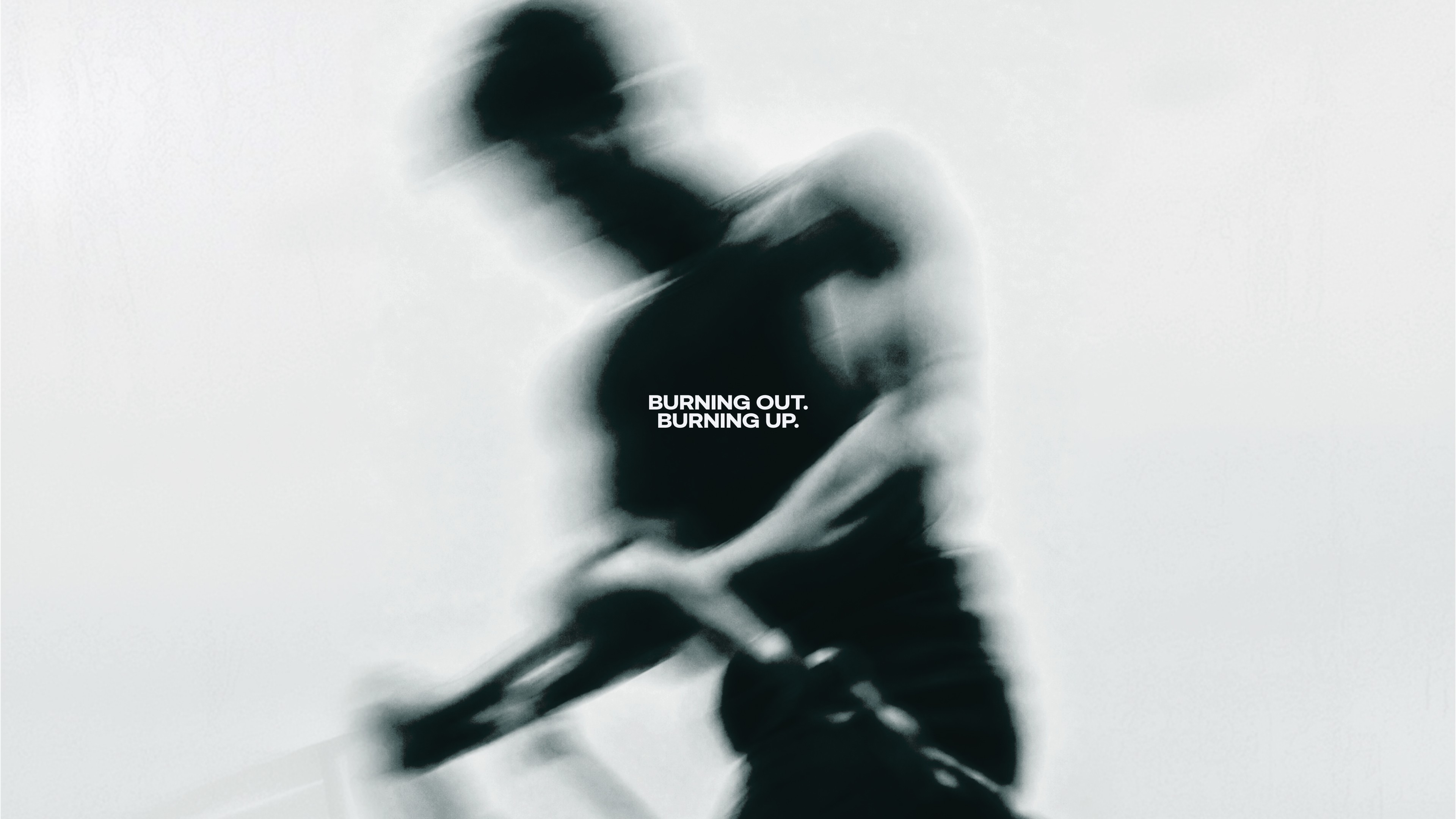 Black and white campaign visual: a motion-blurred athlete gripping a bar, with the line Burning Out. Burning Up. at the centre.