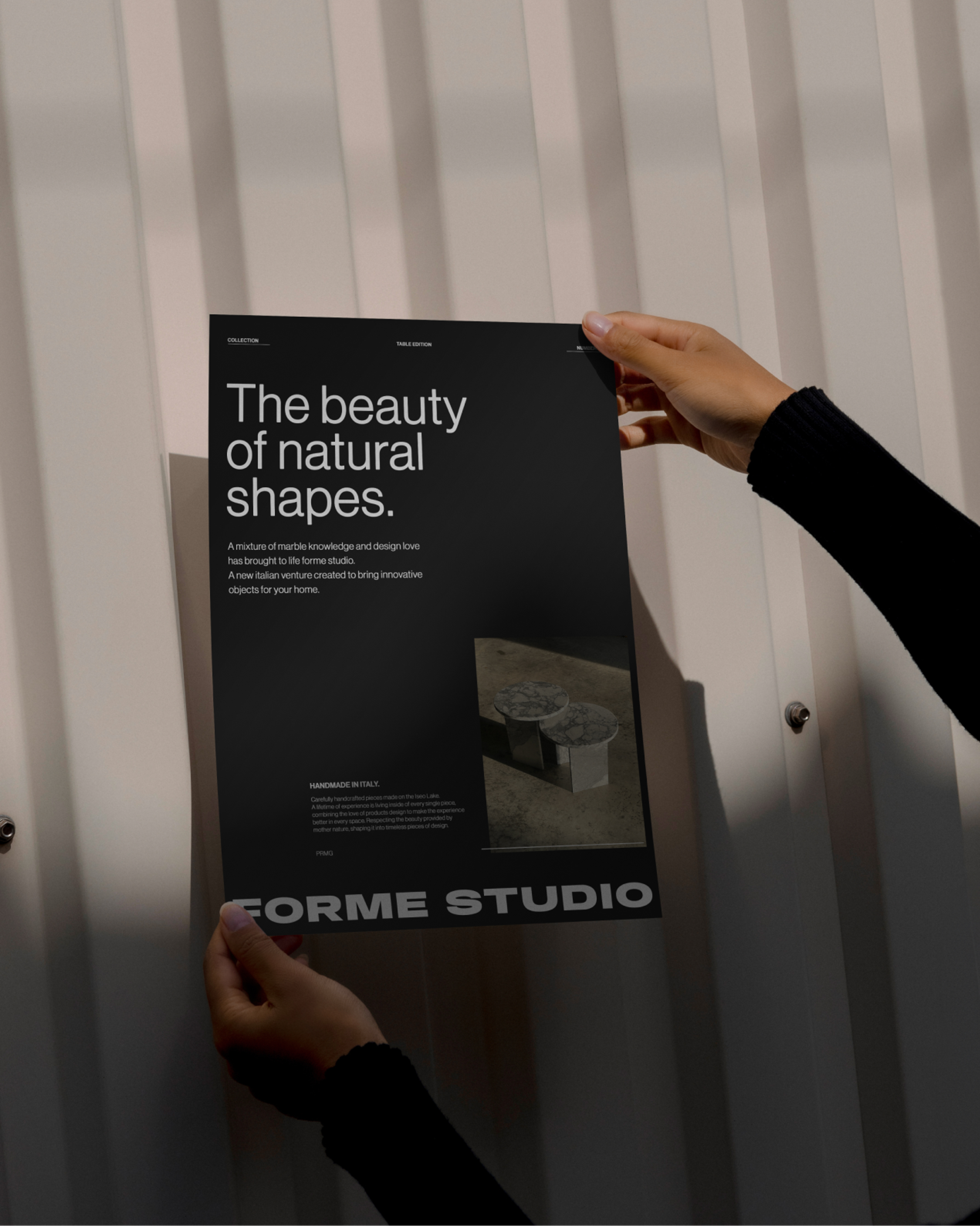 Hands holding a black Forme Studio poster reading The beauty of natural shapes