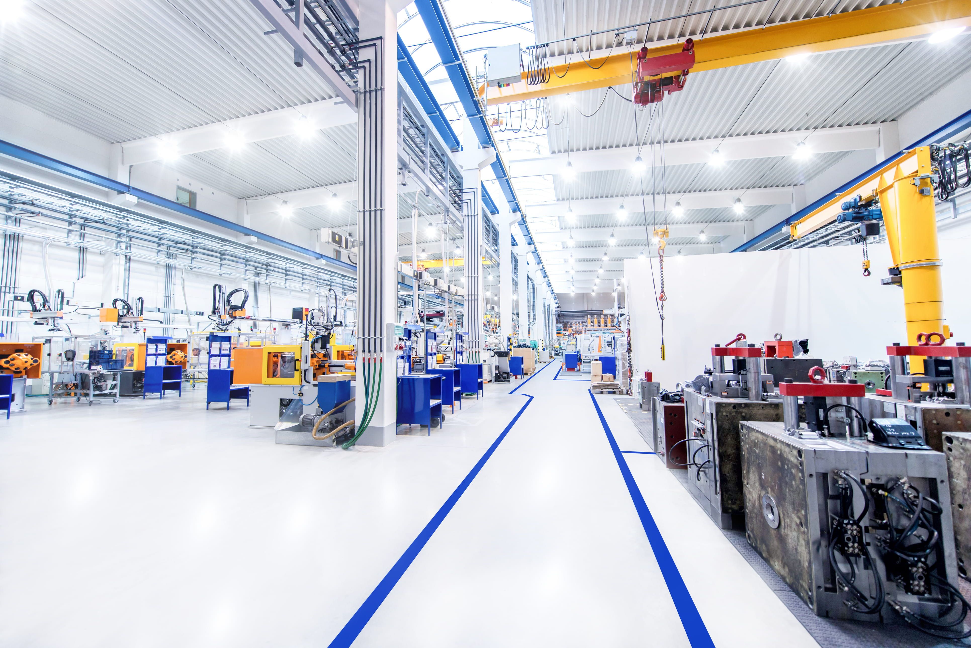 Clean shop floor with blue lines painted on floor and industrial robots