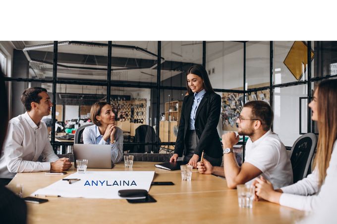 Toimistoväkeä neuvotteluhuoneessa, ilmeet iloisia, neuvottelevat lainasopimuksia paremmalle korolle.