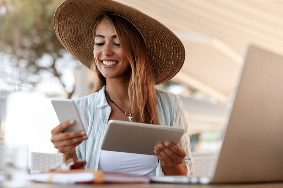 Traveler using a smartphone and tablet while planning a trip, representing digital tools for tourism marketing Hiweb