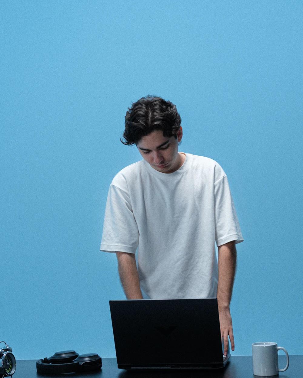 Boy writing on his laptop