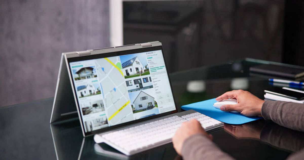 Profesional inmobiliario analizando listados de propiedades y opciones de vivienda en una computadora Hiweb
