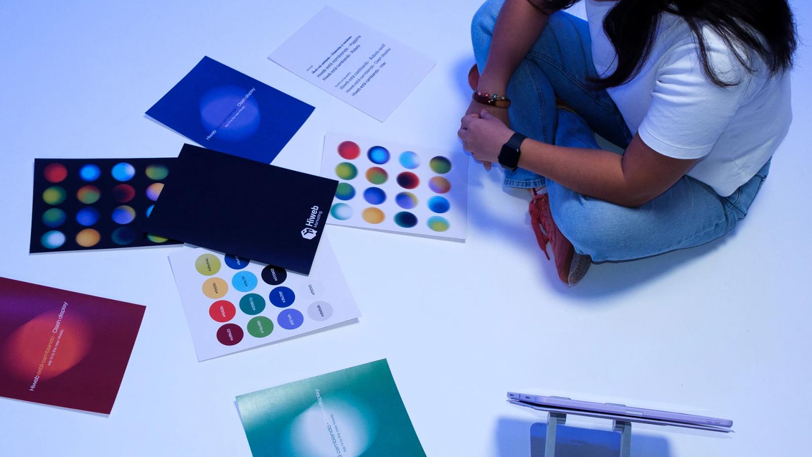 Persona creativa con notas y materiales gráficos para Hiweb